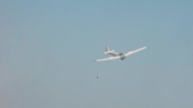 Small vintage training plane lands with engine off at a country airport surrounded by tourist planes and gliders. Slingsby T.61A Falke or Venture G-AYYK a licence-built version of the Scheibe SF 25B