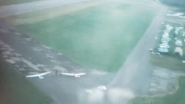 多くの駐車グライダーを持つスポーツ飛行場の低高度の空中視界 パイロットの視点からライト飛行機を着陸 スリングビーT 21オープンコックピット ロイヤルエアフォースのサイド2座席グライダー — ストック動画