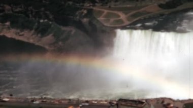 The breathtaking panoramic landscape view of a rainbow at Niagara Falls, New York. Displaying a spectrum of colours in the misty waters. A stunning natural wonder. Historical footage of the 1960