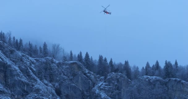Helicopter Hovering Flight Snowy Mountain Rope Hanging Carry Heavy Load — Stock video
