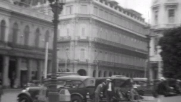 ハバナのダウンタウンにある公園の近くにはアンティークカーが停まっています ハバナ キューバは1930年 ノスタルジックなライフスタイル アーカイブ黒と白の映像 — ストック動画