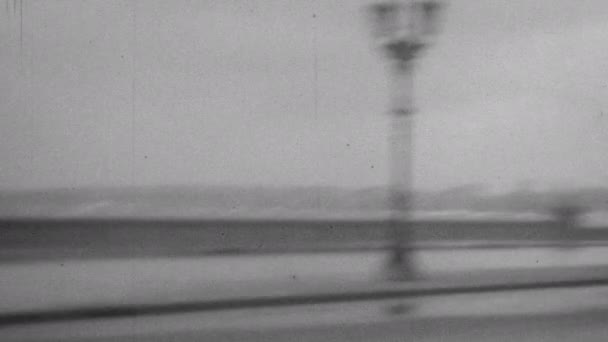 典型的な1930年代の車は 激しい雨と波の強い風の日にハバナのマレコンに沿って運転します 1930年のキューバの高品質な4K黒と白のアーカイブ映像 — ストック動画