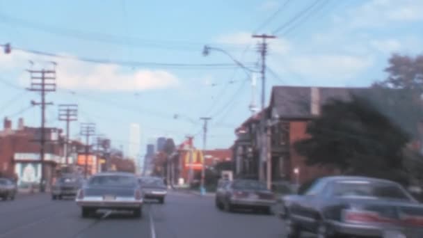 アメリカ車は低速で都市部の道路に沿って運転する 晴れた日 手持ち8Mmノスタルジックなビデオ 70年代のヴィンテージ映像でカナダのトロントのヨンゲ通り — ストック動画