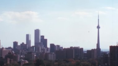 Toronto gökdelenleri, CN Kulesi çok iyi görülebilen şehir manzarası. Güneşli bir gün, birkaç beyaz bulutlu mavi bir gökyüzü. Tipik 8 mm film efektiyle 1970 'lerin geniş açılı klasik stok görüntüleri. 