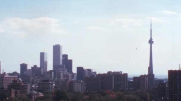 Cnタワーがよく見えるトロントの高層ビル街 晴れた日には いくつかの白い雲と青空 典型的な8Mmフィルム効果で1970年代のワイドショットヴィンテージストック映像 — ストック動画