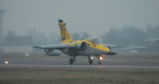 喷气式战斗机滑行与美国本土人的轮廓描绘在黄色的尾巴黑色 意大利空军Amx Ghibli 北约灰色机身 冬季阴冷天 — 图库视频影像