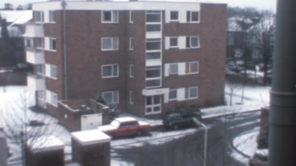 纽约1970年代 放大从上方看到的一座棕色砖楼的白色入口门 七十年代的冬日 路边飘着雪 停着汽车 — 图库视频影像