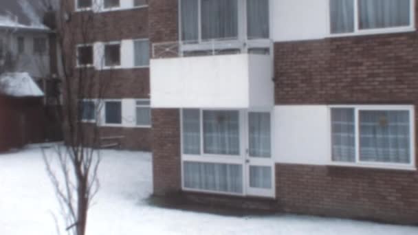 茶色のレンガ造りの建物の白い入り口のドアにズームします 地面に雪と冬の日 ニューヨーク1970年代 — ストック動画
