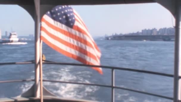 1970年代在纽约港从一艘移动中的船舶的斯特恩飘扬的美利坚合众国国旗 — 图库视频影像