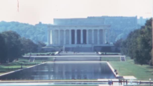 林肯纪念堂的立面是1970年代华盛顿特区的白色柱子和湖泊 无法辨认的人在花园中行走 — 图库视频影像