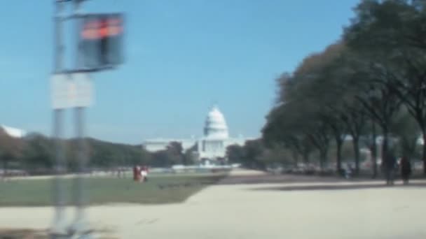 アメリカ合衆国議会議事堂1970年代の歴史的なビデオでワシントンD の通りに移動する車の乗客の観点から建物 青空が広がる晴れた日のパノラマビュー コピースペース — ストック動画