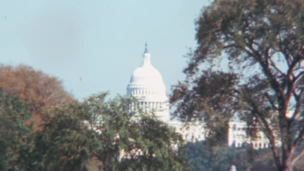 ワシントンD のアメリカ キャピトル ビルディングのホワイト ドーム 1970年代の晴れた日に青空と緑の木の後ろに コピースペース — ストック動画