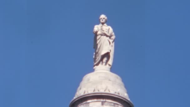 ボルチモアのワシントン記念碑の列の上に最高司令官としてジョージ ワシントンの辞任の銅像 1970年代ヴィンテージ映像 青空を背景にした晴れた日 — ストック動画