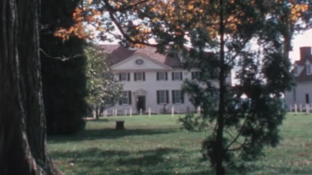 1970年代のヴィンテージ フッテージの緑の木々の間を背景に マウントバーノンのジョージ ワシントン ハウス 晴れた日の静的なビュー スーパー8レトロ効果 — ストック動画