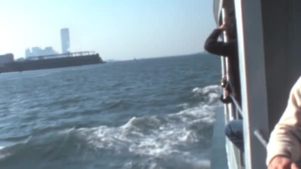 1970年代の観光客は 晴れた日にセーリング船からニューヨーク港を賞賛しました マンハッタンの高層ビルを背景に — ストック動画