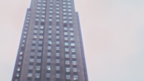 纽约洛克菲勒中心摩天大楼 20世纪70年代 阳光灿烂的日子 顶底倾斜 基底上的普罗米修斯青铜雕塑 — 图库视频影像