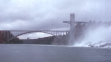 Prospect Point Observation Tower ve Niagara Şelalesi 'ndeki Uluslararası Gökkuşağı Köprüsü: 1970' lerin Panoramik Sahne Arşivi 8 mm Film Reel Restorasyon. Bulutlu Gökyüzü. Boşluğu Kopyala.