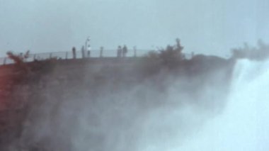 Turistler Niagara Şelalesi 'ne yukarıdan hayrandır. Alt gölde yelken açan bir teknenin manzarası. Uzaklaş. Büyük miktarda su, sıçramalara neden olur. Eski görüntülerdeki Niagara şelaleleri.