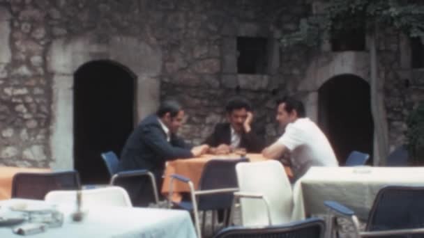 3人の白人男性がモスタルのレストランの屋外テーブルで食事をしています 1970年ボスニア ヘルツェゴビナのアーカイブ映像 — ストック動画