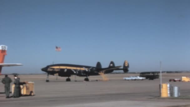 1950年代的客机在美国空军基地停放 美国国旗飘扬 美国空军飞行示范中队蓝色和黄色洛克希德L 1049蓝天使超级星座 — 图库视频影像