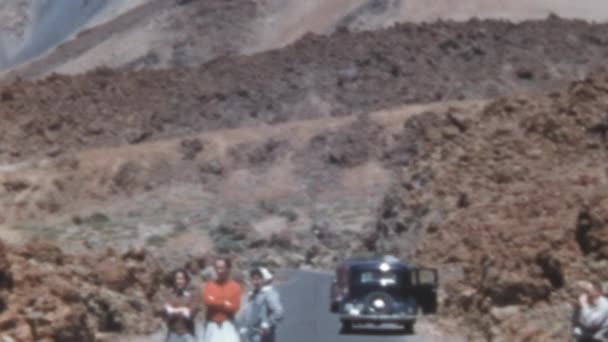 テネリフェ島のTeide火山自然公園を歩く観光客 1950年代カナリア諸島のアーカイブ映像 ラスカナダの風景の中に青空と晴れた日 ヴィンテージブラックカー道路上に駐車 — ストック動画
