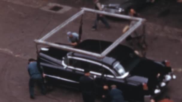 豪華なビッグアメリカン車は 船にそれをロードするクレーンにフックされています ブラック キャデラック フリートウッド 1950年代のヴィンテージ映像 サニーデー — ストック動画