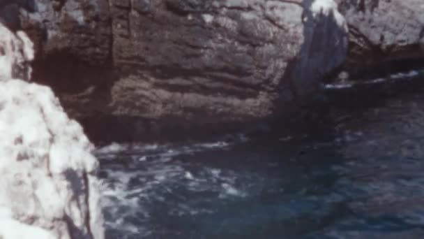 澄んだ青い海の大きな波水が岩を襲い グラン カナリア海岸線で泡を作ります カナリア諸島の1950年代のヴィンテージ映像 夏の晴れた日 — ストック動画
