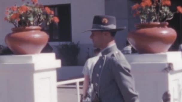 暗いスーツを着た年配の男性は スペインの警備員によって そして1950年代に建物のグラン カナリア スペインに向かって歩いています 暑い夏の日 男は帽子と制服を着ている 短い2つあります — ストック動画