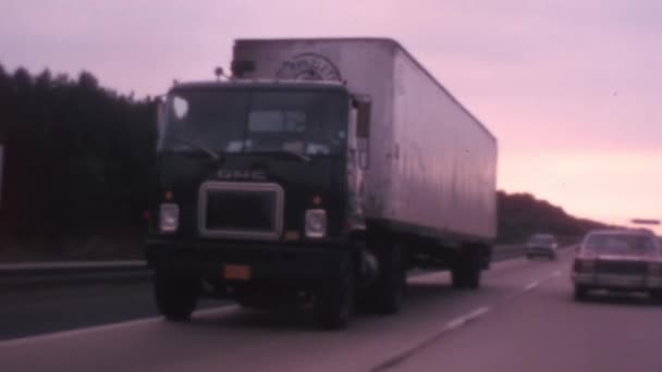 ペンシルベニア ターンパイクで忙しい双方向高速道路の道路を移動するレトロなトラックや歴史的な車のコンテナ 両側の木々や背景に澄んだ空を持つ高速道路 ヴィンテージ映像 — ストック動画