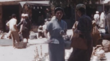 Turistler ve yerel halk, Fas El Jadida 'nın yol kenarındaki bir pazarında. Fas 'ın Atlantik kıyısında büyük bir liman kenti ve turizm beldesi. 1950 'nin tarihi görüntüleri.