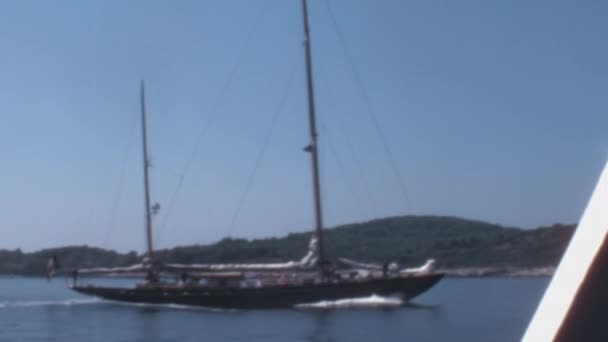 ドゥブロヴニク海岸の輝く水を透明な青空に向かって航行する船 1970年のこの魅惑的なストック映像は この海岸のシーンの穏やかな美しさを捉え 瞬間を提供しています — ストック動画
