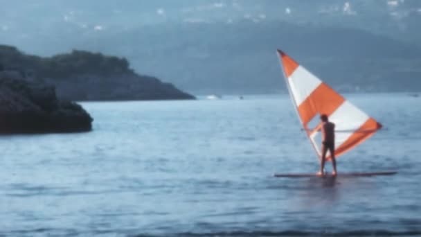 1970年代にクロアチア出身のクロアチアのドゥブロヴニク近くのアドリア海の広大な広大な範囲の中で 水中のウインドサーフィン 壮大な岩の形成を背景に — ストック動画
