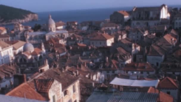 ドゥブロヴニク旧市街のパノラマは 古代の壁の上から澄んだ青空に対して ローマ大聖堂と小さな赤い屋根付きの家を備えています ユーゴスラビア 今クロアチア 1970年代のアーカイブ映像 — ストック動画