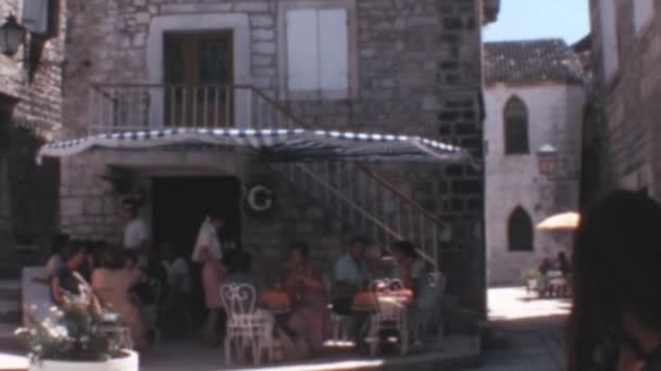 クロアチアの古い町スプリットの外側の階段を持つ小さなカフェでリフレッシュしている観光客 1970年代のユーゴスラビアのライフスタイル史料 — ストック動画