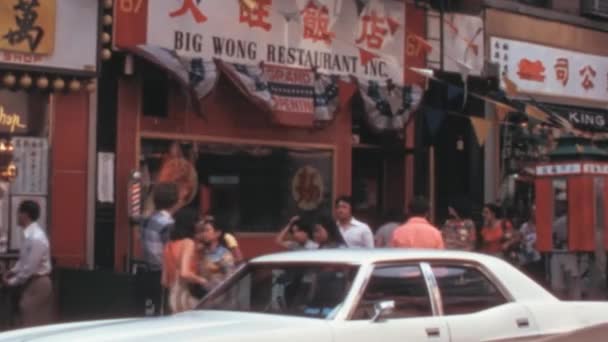 上世纪70年代在纽约市唐人街的一家中餐馆的特写 一辆白色的汽车停在餐馆前面 很多人在走路完美的纪录片和历史电影 — 图库视频影像