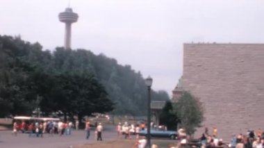 Niagara Şelalesi 'nin manzaralı güvertesinde, Ontario Kanada' da turist kalabalığı. Arka plandaki Skylon Kulesi. 1970 'lerin Arşiv Videosu.