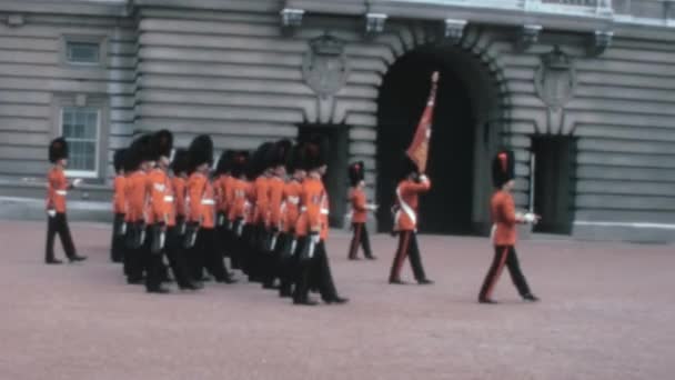 1970年代の軍事伝統のレトロ映像は イギリスのバッキンガム宮殿の外で行進するコールドストリーム警備隊を示している — ストック動画
