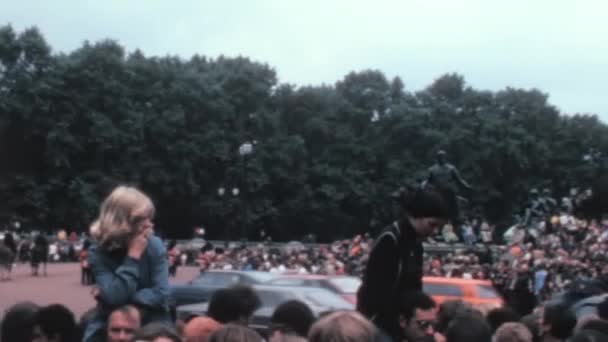 上世纪70年代维多利亚纪念馆的这段历史录像显示 人们聚集在伦敦的白金汉宫 让路给英国皇家车通过 — 图库视频影像