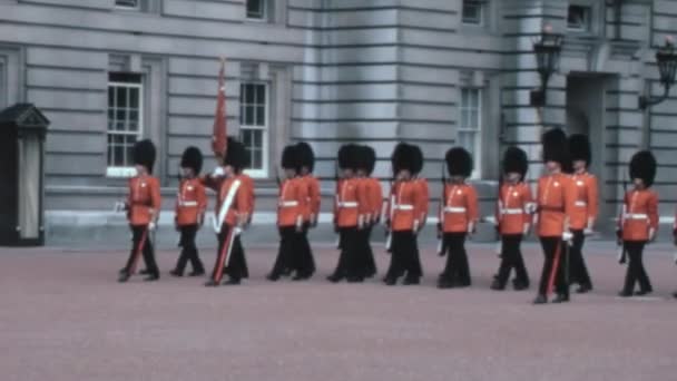 1970年代のアーカイブ映像は ロンドンのバッキンガム宮殿でコールドストリーム警備隊の軍事伝統が行われている重要な日を撮影します — ストック動画