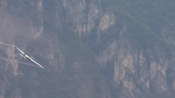 急な木造の山の壁の上に着陸するためのグライダーの準備 グライダーは低く飛行しており パイロットは高度と方向を維持するためにコントロールに調整しています 背景について — ストック動画