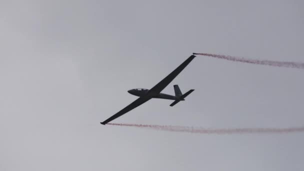 高速グライダーは 灰色の悪天候の空で翼の煙で真空中に登ったり垂直に上昇したりします エアロダイナミック スキル パワーのインスパイアディスプレイ — ストック動画