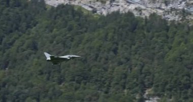 Alman Hava Kuvvetleri Luftwaffe 'nin Eurofighter Typhoon savaş uçağı alçak irtifa ve yüksek hızda Alp Vadisi' nde süzülür. Jet, dağ yamacından kayarak hava muharebe manevraları yapıyor.