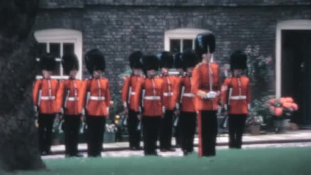 1970年代のロンドン塔のクイーンズハウスの庭で複雑な儀式を行ったコールドストリーム警備隊のアーカイブ映像 — ストック動画