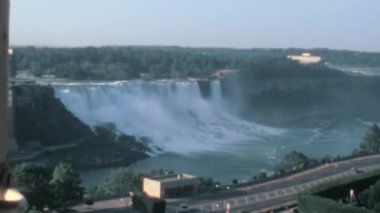 Niagara Şelalesi 'nin panoramik hava manzarasını üsteki Niagara Elektrik Santrali' nin belirgin varlığıyla gösteren 1970 'lerin arşivi. Bu tarihi video benzersiz bir perspektif sunar