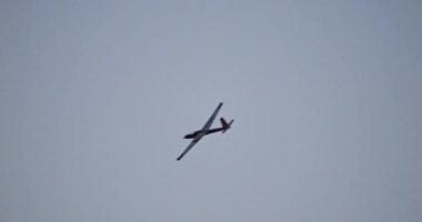 Gün batımından sonraki loş gökyüzünde siluetli planör, selamlama işareti olarak nazikçe kanat çırpıyor. Huzuru ve alacakaranlık güzelliğini çağrıştırıyor. Yüksek kalite 4k görüntü.