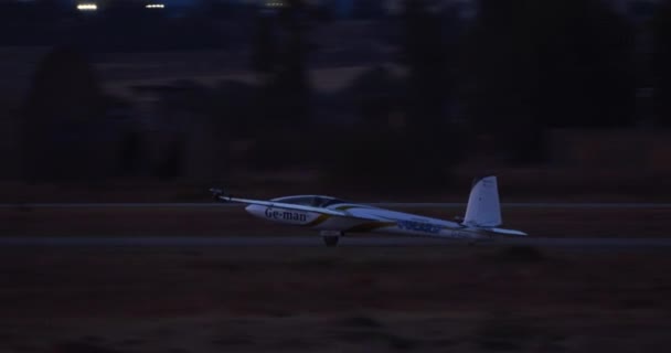 空港滑走路で滑らかに減速するグライダー 航空機の精度とトワイライトの操作をイラストします 高品質の4K映像 — ストック動画