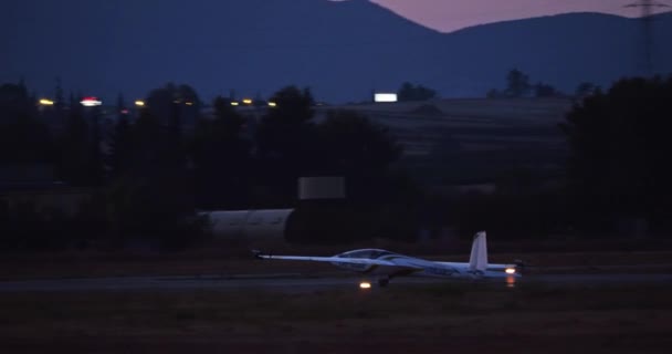 Glider Bromsar Och Stannar Banan Efter Twilight Landing Stadsljus Avstånd — Stockvideo