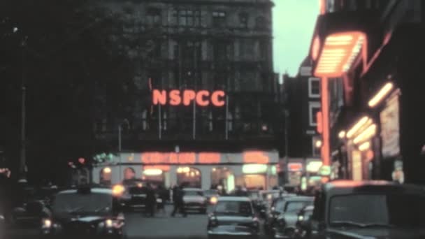 环城商场和餐馆明亮的霓虹灯标志 经典汽车以行人为背景 驶过街道 1970年代的伦敦 — 图库视频影像
