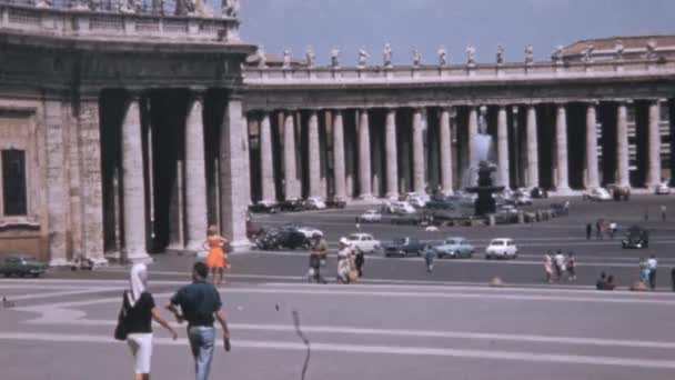 サンクトペテルブルク広場の歩行者と車 フォンタナ メデルノの背景 サンピエトロ広場の中心に位置する大きな大理石の噴水 ドルチェ ヴィータ時代のヴァチカン都市 — ストック動画