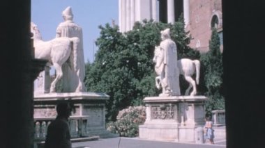 İnsanlar Piazza del Campidoglio 'da Colossal Statues arasında yürürler. Roma 'nın güzel ve tarihi meydanı. Vittoriano ile birlikte Capitoline Hill 'de yer almaktadır. 1960 'ların Roma Vintage Dolce Vita Dönemi.